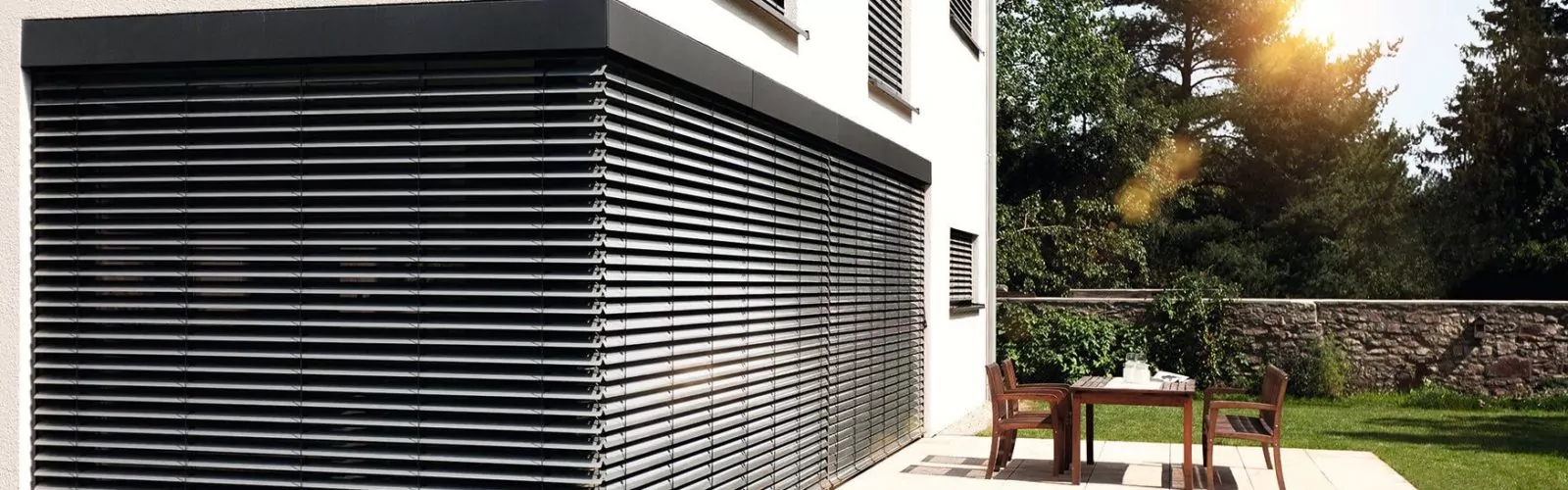 Außenjalousien nachrüsten an modernem weißen Haus mit Terrasse
