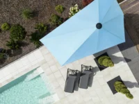 Luftaufnahme eines modernen Gartens mit Pool und blauem Sonnenschirm